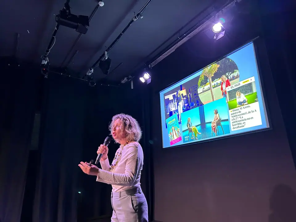 Diana dando una charla en un escenario
