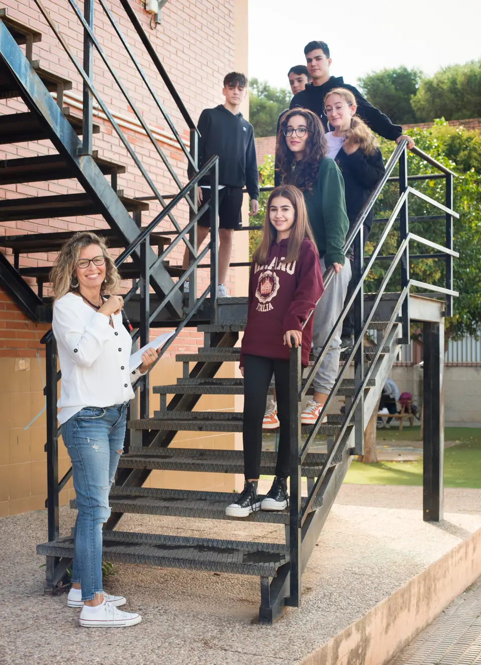 Diana con adolescentes en una escalera del instituto