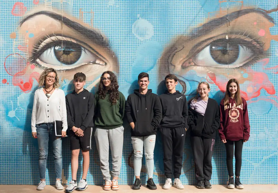 Diana con un grupo de adolescentes delante de un mural